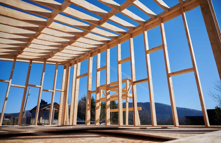 Timber frame house on pile foundation under construction in the mountains
